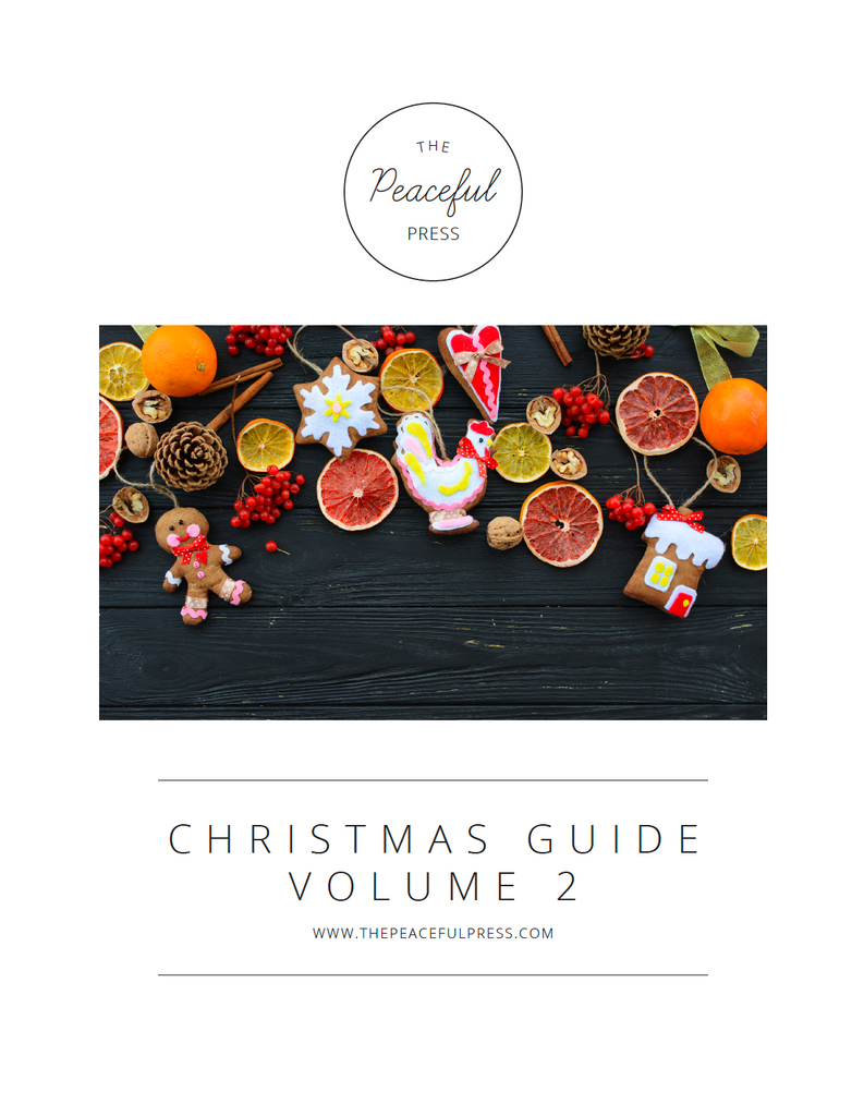 Cover art for Volume Two of the homeschool Christmas Guide, dried fruit and other Christmas themed baking goodies on a black wooden table.
