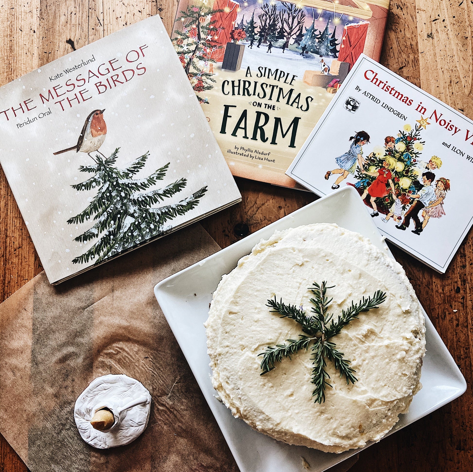 A winter spice cake on a square plate next to 3 christmas themed books. 