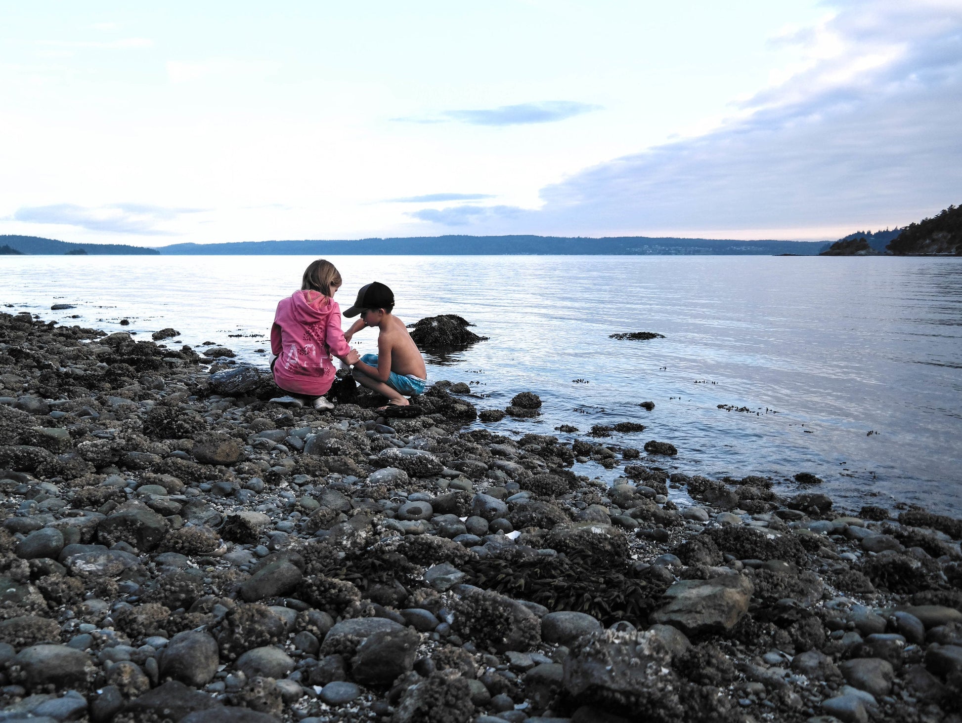 Two homeschool kids on the edge of the a large lake.