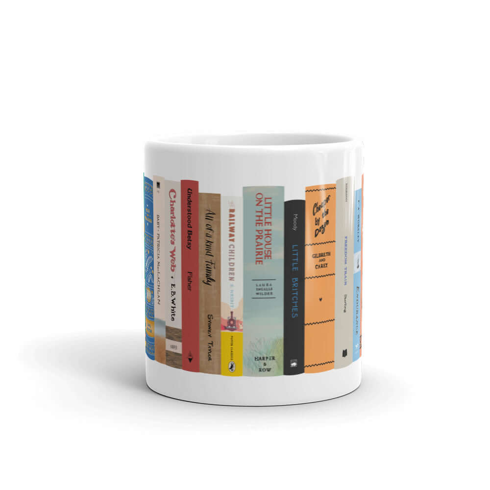 The Peaceful Preschool Mothering By The Book mug in white with a painting of a bookshelf with books on it.